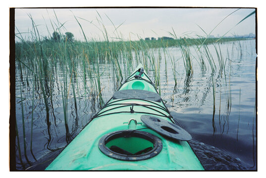 Kayak on a lake surrounded by tall grass in the evening
