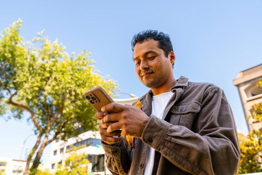 candid casual man using cellphone outside downtown san jose, cali