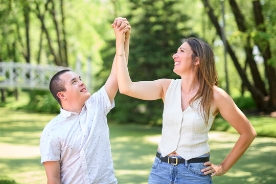 boy with Down syndrome in a park with his mother