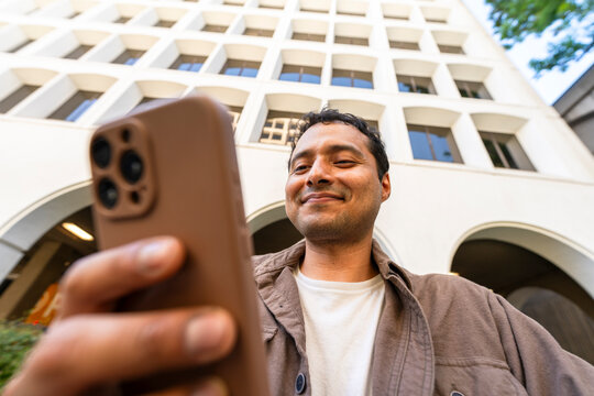 low angle casual man using mobile phone city office building