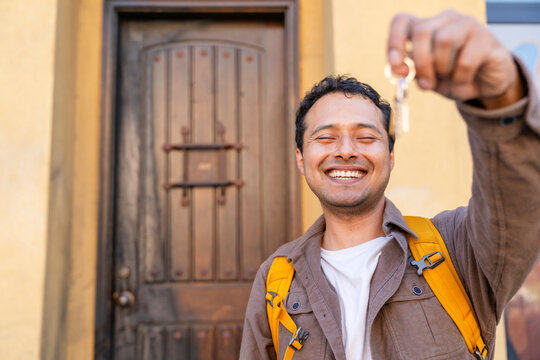 Happy homeowner house keys in front of door