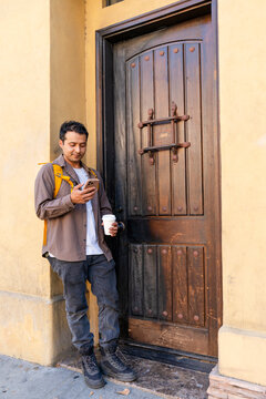 standing by door using smartphone