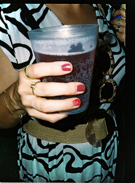 Person holding a drink in plastic cup at party