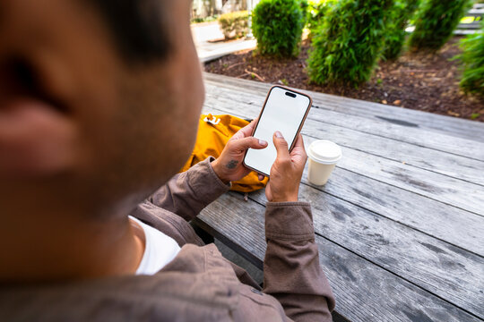 man using blank mobile phone public table
