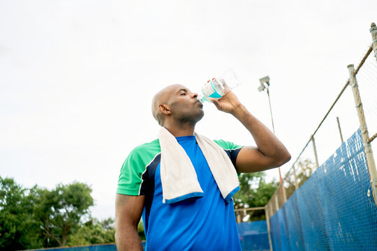 Black man hydrating after exercising