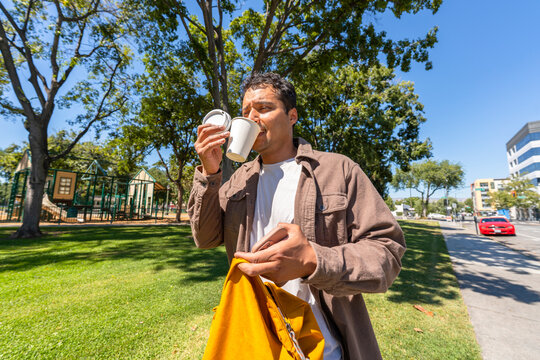 busy casual city man on the go drinking coffee cup multitasking