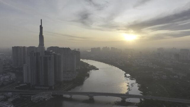 Aerial drone view of Landmark 81 in Thanh My Tay Ward, Ho Chi Minh City, Vietnam, with bright sunlight illuminating the iconic skyscraper and surrounding modern urban landscape.
