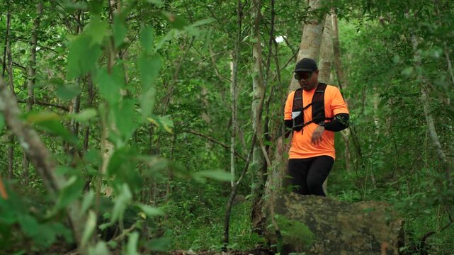 Man trail running through a forest during an outdoor workout. He challenges himself to improve fitness and endurance while pursuing personal goals and a healthy active lifestyle.
