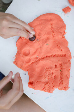Child make prints on the dough using  natural material 