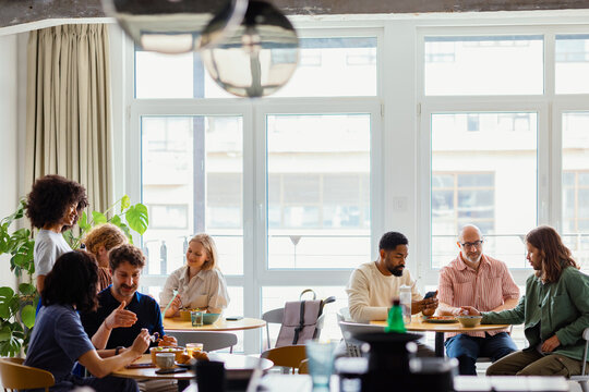 Diverse Group of Business People Socializing Over Lunch In a Cafe