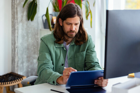 Focused Man Working on Tablet at Office