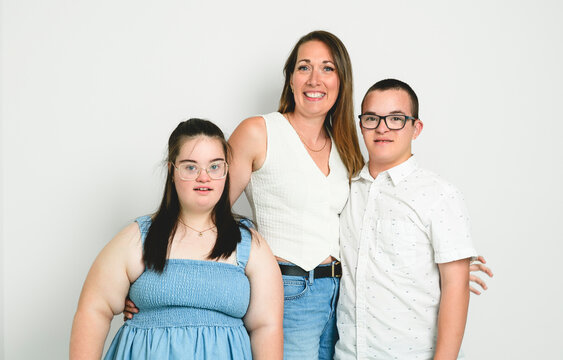 kid with two Down syndrome kid over white background with his mother