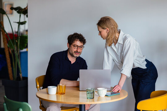 Colleagues Collaborating Over Laptop During Office Meeting