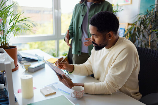 Team Collaborating in Modern Office Using Tablet