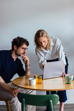Coworkers Discussing Project Over Laptop At Table