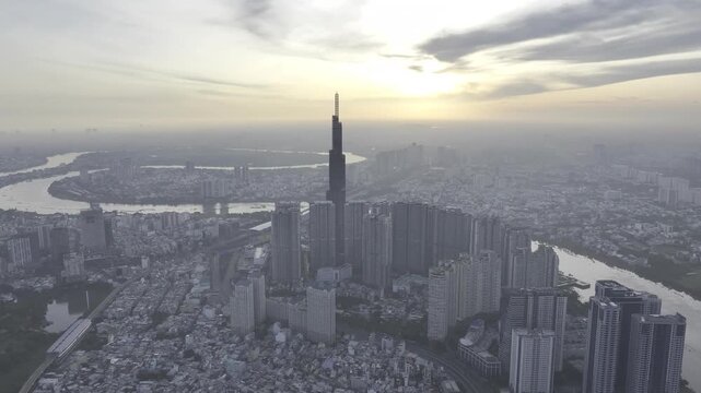 Aerial drone view of Landmark 81 in Thanh My Tay Ward, Ho Chi Minh City, Vietnam, with bright sunlight illuminating the iconic skyscraper and surrounding modern urban landscape.