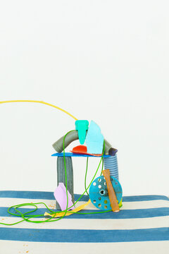 Sculpture with pieces of colourful plastic on a striped background 