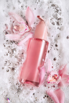 Pink Skincare Serum Bottle With Orchid Flowers and Soap Foam