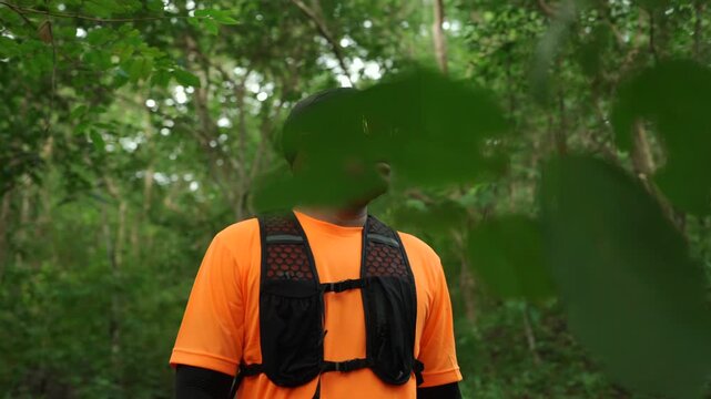 Man trail running through a forest during an outdoor workout. He challenges himself to improve fitness and endurance while pursuing personal goals and a healthy active lifestyle.
