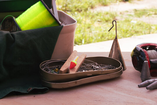 Fishing tackle and gear spread on a wooden surface, ready for an outdoor activity, highlighting leisure, hobby, and relaxation by the water