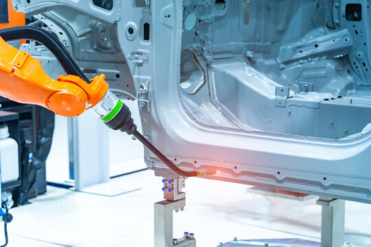 Industrial robotic welders weld the car body on factory. Machine robot arm. Smart industry. Automobile production