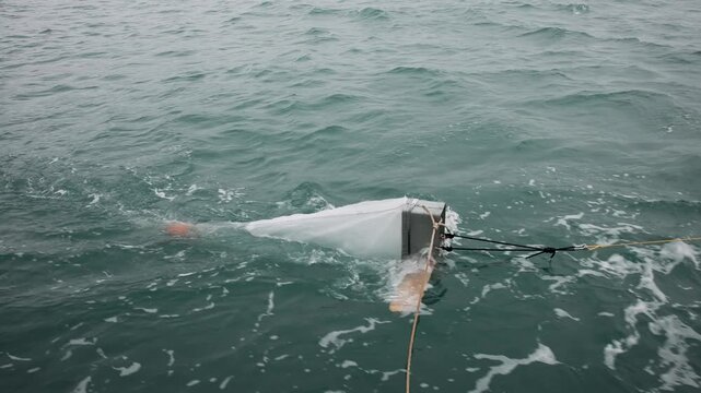 Scientists gathering data about microplastic pollution in the ocean with a manta trawl