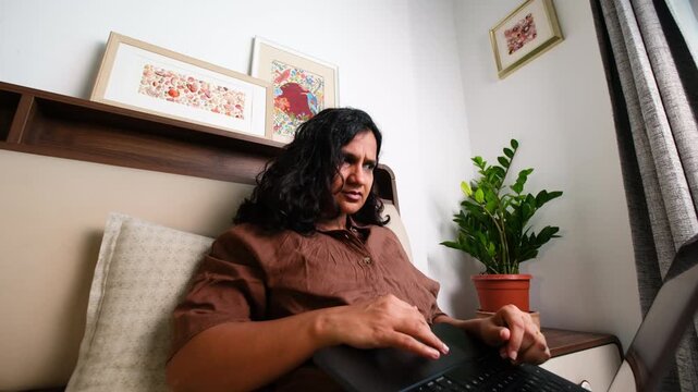 Stressed woman working from home on laptop from dramatic low angle, remote work pressure, mental fatigue, anxiety, burnout and digital overload concept