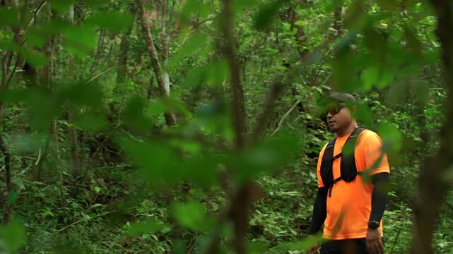Determined man trail running through a forest during an extreme outdoor workout. He pushes his limits while pursuing fitness goals, endurance personal achievement through an active healthy lifestyle.
