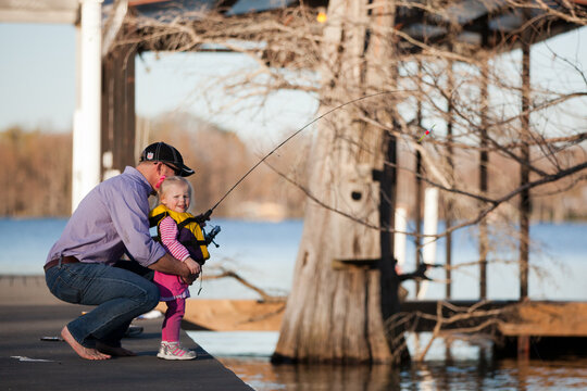 man and little girl fishing