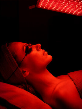 Red Light Therapy Facial Treatment With LED Panel in Dark Beauty Clinic Setting