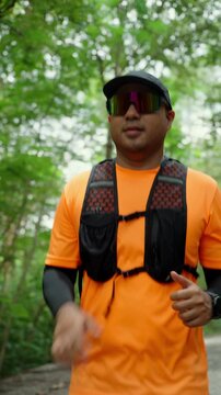 Determined man trail running through a forest during an extreme outdoor workout. He pushes his limits while pursuing fitness goals, endurance personal achievement through an active healthy lifestyle.
