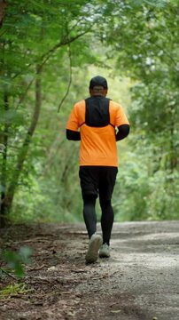 Determined man trail running through a forest during an extreme outdoor workout. He pushes his limits while pursuing fitness goals, endurance personal achievement through an active healthy lifestyle.
