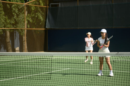Young Asian Girl Tennis Beginner Learning to Play with Coach on Outdoor Court