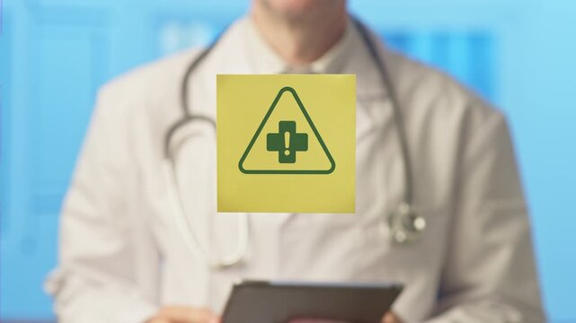Unrecognizable physician in a white lab coat holding a tablet and showing a sticker with a medical warning sign, representing a health hazard, risk, or important health information