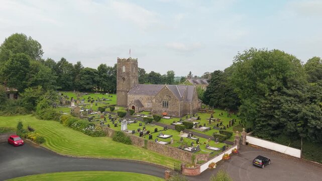 Aerial descent towards the 17th century St Michael's Church of Ireland and its walled graveyard, Castlecaulfield, County Tyrone, Northern Ireland