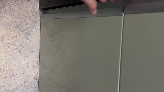 A kitchen cabinet door opens and closes by hand, showing everyday household movement and authentic furniture sounds in a home interior. High quality FullHD footage