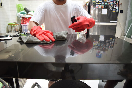 Young husband in household concept. A man cleaning kitchen