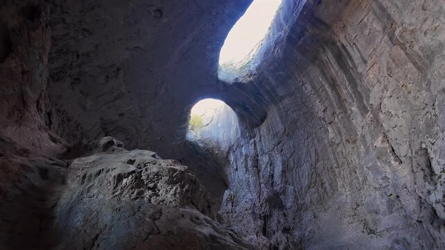 Incredible view of the Prohodna Cave, a natural landmark in Bulgaria also known as the Eyes of God, with sunlight illuminating its interior
