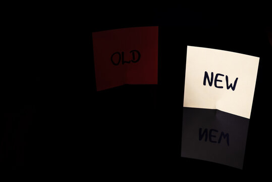 Orange &ldquo;OLD&rdquo; and yellow &ldquo;NEW&rdquo; notes on a dark reflective background, symbolizing change, transition, decisions, mindset shift, transformation, progress and emotional contrast.