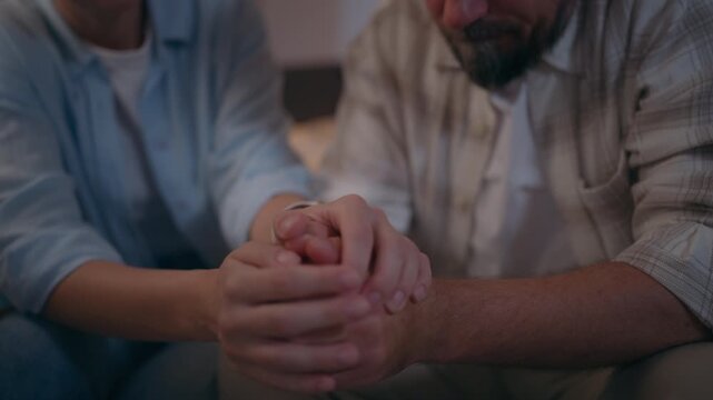 Woman holding husband&rsquo;s hands during a difficult family situation, providing comfort and reassurance while the couple faces emotional stress, uncertainty and personal challenges.