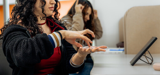 Fototapeta premium Woman learning sign language with tablet in classroom