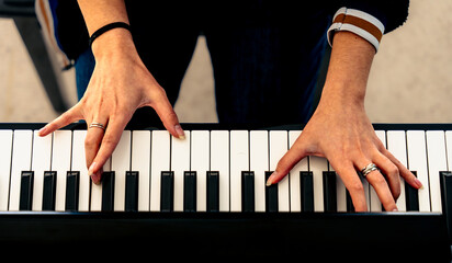 Musician playing keyboard creating music with hands © Fabian Vargas