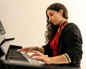 Young woman playing piano practicing musical instrument © Fabian Vargas