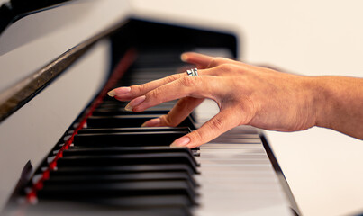 Woman playing piano keys creating music © Fabian Vargas