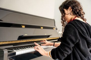 Woman playing piano creating music learning skills © Fabian Vargas