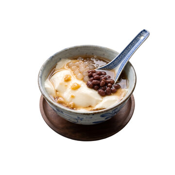 Traditional Asian tofu pudding dessert with red beans and tapioca pearls in a ceramic bowl.