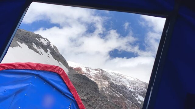 Clouds drift over Mount Ararat in tent-framed view from the high camp in Turkey, showing changing mountain weather, expedition shelter, altitude conditions, summit preparation during acclimatization