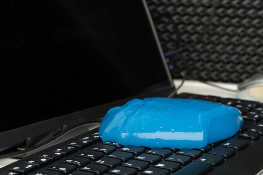 Keyboard covered with blue substance on a laptop near a screen
