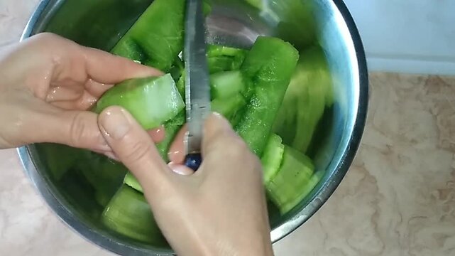 Dicing fresh nopal cactus pad and placing pieces in a bowl 