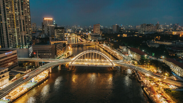 Manila skyline, Binondo-Intramuros Bridge, and Pasig River at night with illuminated city lights in the Philippines